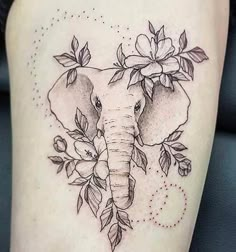 an elephant with flowers on it's head is shown in this tattoo style photo