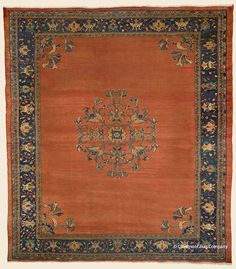 an orange rug with blue and gold designs on the center, surrounded by smaller flowers