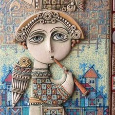 a ceramic artwork depicting a woman with a pipe in her mouth and buildings on the other side