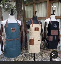 three mannequins wearing aprons with leather straps