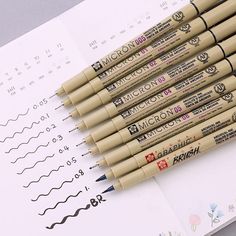 six pencils are lined up on top of a piece of paper with numbers and symbols