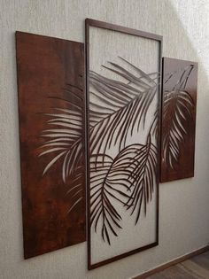 two paintings on the wall with palm leaves painted on them in brown and white colors