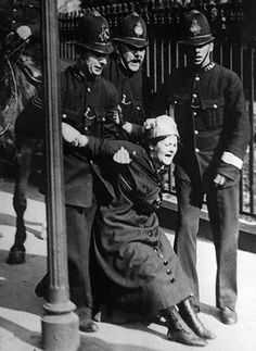 an old black and white photo of a woman being assisted by police officers on horseback