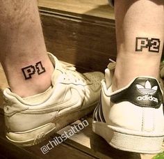 two people with matching tattoos on their legs, one has the letter p and the other has