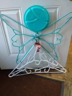 a door hanger with a plastic butterfly on it's side and a blue ball hanging from the top