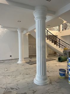 an empty room with marble floors and pillars in the center, surrounded by paint rollers