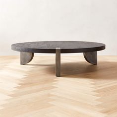 a round table with two metal legs on a wooden floor