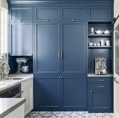 a kitchen with blue cabinets and white counter tops