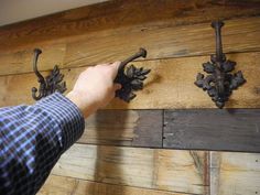 a person is trying to fix an old door handle on a wooden paneled wall