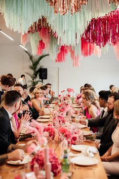 a group of people sitting at a long table with plates and napkins on it