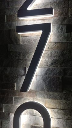 the number seven is lit up in front of a brick wall