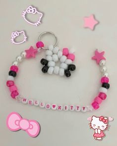 a hello kitty key chain is shown with pink and white beads on it, along with other accessories