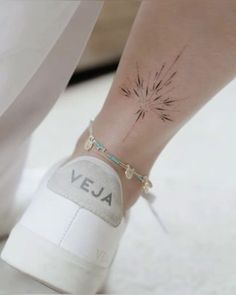 a woman's foot with a flower tattoo on her left ankle and the word vera written across it