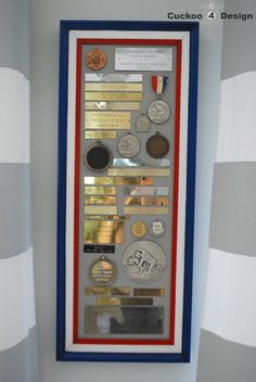 a display case with medals and other items on it's side, hanging from the wall