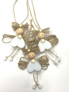 three angel ornaments hanging from twine with stars