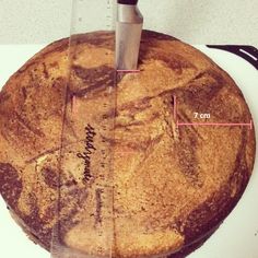 a cake is being cut by a knife on a white plate with a measuring tape