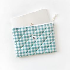 a blue and white checkered bag with a tag on it