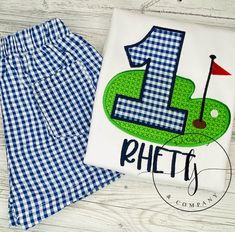 a shirt with the number one on it next to a pair of blue gingham shorts