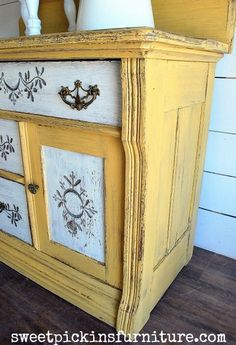 an old dresser has been painted yellow and white