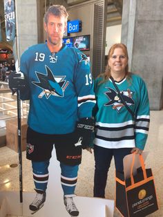 a man and woman standing next to each other in hockey jerseys