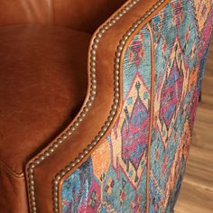 a brown leather chair sitting on top of a wooden floor