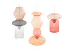 three different colored lamps hanging from the ceiling in various shapes and sizes, each with a single light bulb at the top