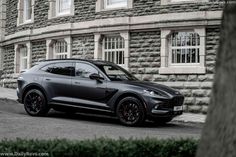 the new porsche cayen is parked in front of a stone building with white windows