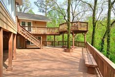 a wooden deck with stairs leading up to the second floor and two decks on each side