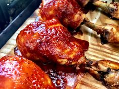 chicken wings covered in bbq sauce sitting on a cutting board next to an oven