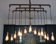 a bunch of light bulbs hanging from a chandelier over a stove top oven