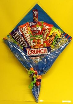 a bag filled with candy and candies on top of a yellow table next to a blue wall