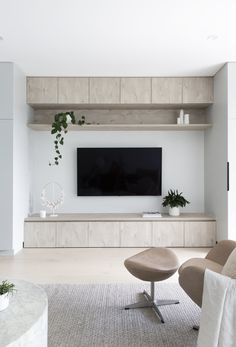 a living room filled with furniture and a flat screen tv mounted on a wall above it