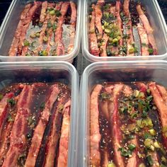 four plastic containers filled with different types of meats and seasonings on top of each other