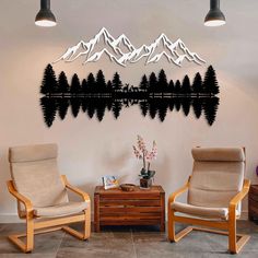 two chairs sitting next to each other in front of a wall with mountains on it