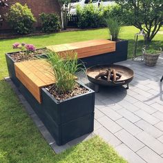 a fire pit sitting on top of a brick patio next to a garden filled with plants