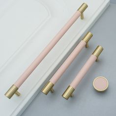 two pink and gold handles on a white sink