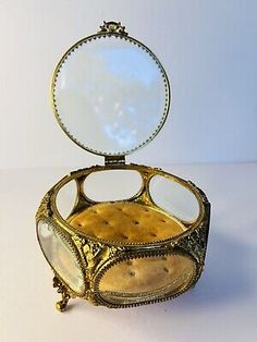 an antique brass jewelry box with mirror in it