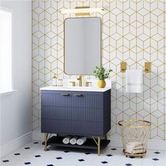 a bathroom with a blue vanity and gold accents on the wall, along with a white tiled floor