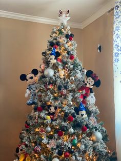 a christmas tree decorated with mickey mouse ornaments