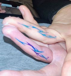 two hands with blue ink on them are touching each other's fingers, while the other hand is holding another person's finger