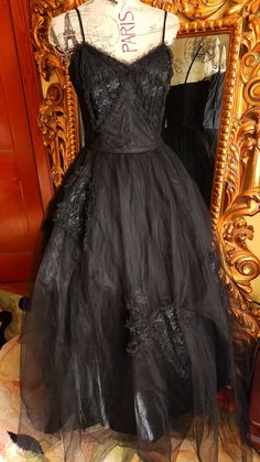 "This gorgeous formal gown is from the 50s by Emma Domb.  Rare solid black.  The underdress is made up of a black shiny acetate. There are two layers of tulle.  The under layer is a coarse tulle to give it its shape.  The outer layer is a finer tulle.  On the bodice and on the skirt are large lace bow appliques. The bodice is boned for structure. Side metal zipper.  There is one repair on the satin underdress near the hem where it looks like the original owners high heel might have gone through. You can't see this  when wearing the dress.  The hem of the tulle in some places has been trimmed (shown) This also does not show because of the fullness and the double layer of tulle.  This is a gorgeous gown and perfect for any formal event or Prom.  It was photographed with an extra petitcoat (n Black Organza Evening Gown, Gothic Ball Gown For Evening, Black Tulle Ball Gown For Formal Events, Black Tulle Ball Gown For Formal Occasions, Formal Black Tulle Ball Gown, Black Organza Gown For Gala, Vintage Black Gown For Wedding, Vintage Black Wedding Gown, Black Tulle Ball Gown For Evening