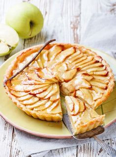 an apple pie on a plate with a slice cut out