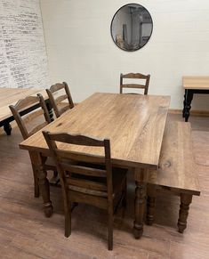 a wooden table with four chairs around it in a room that has white brick walls and wood flooring