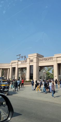 people are walking in front of the university building