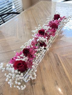 a vase filled with flowers on top of a wooden table