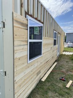 the side of a tiny house with windows and sidings on it's sides