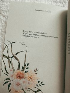 an open book with some flowers on it