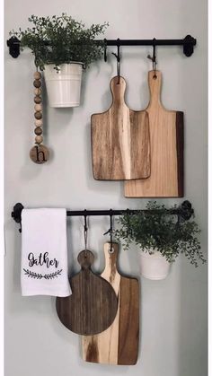 three wooden cutting boards hanging on a wall