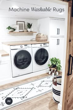 a washer and dryer in a room with white walls, wood floors and cabinets