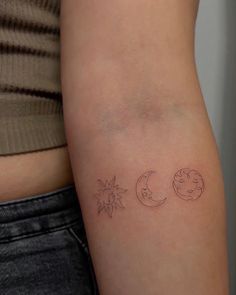 a woman's arm with three small tattoos on the left side of her body